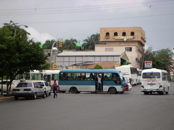there are two blue and white busses stopped at the street