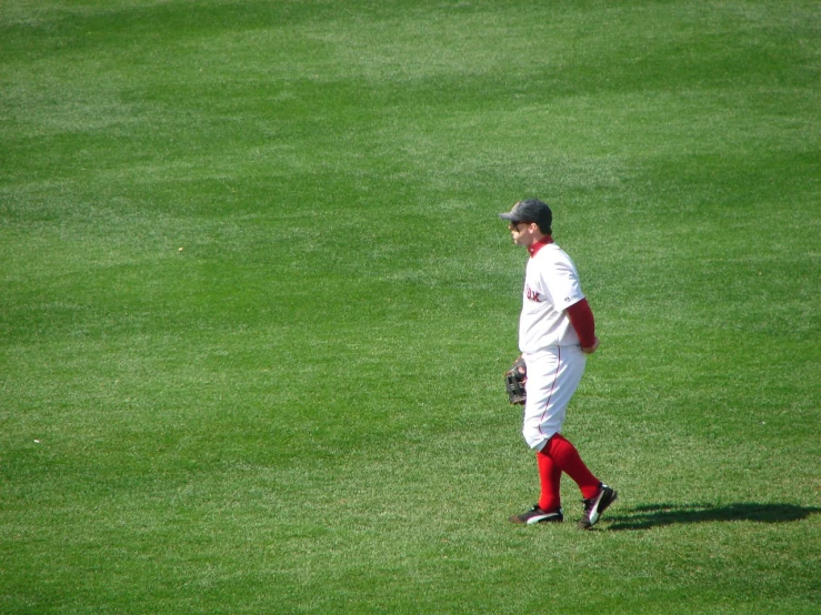 a baseball player standing on top of a field holding a glove