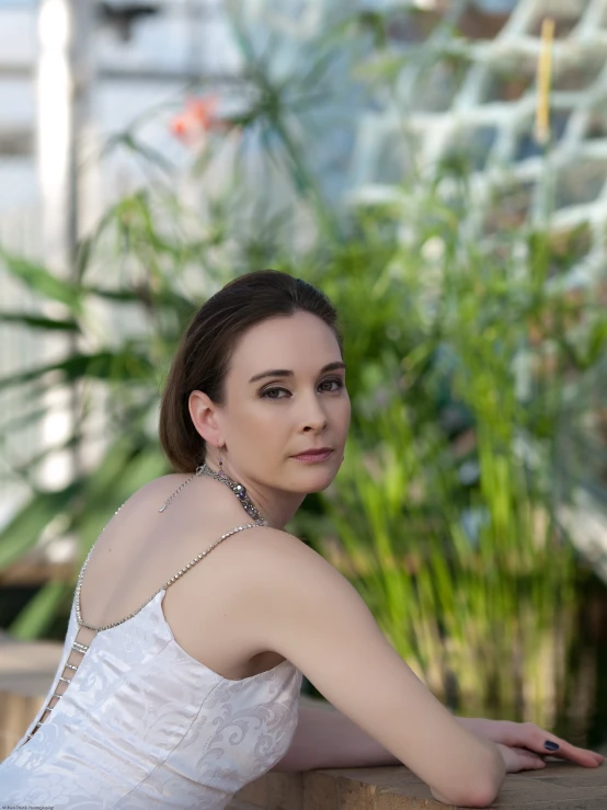 a woman in a white dress laying on a stone wall