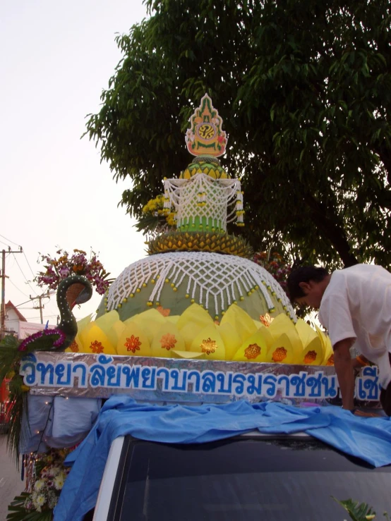 two men making an outdoor flower installation near trees