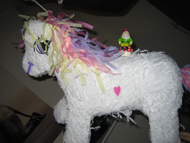 a white pony made of paper and a plastic gnome