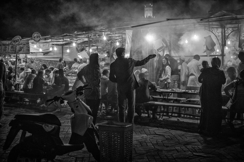 black and white pograph of a festival with smoke rising up in the air