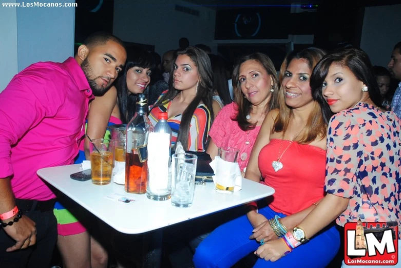 group of young people sitting at a table with drinks