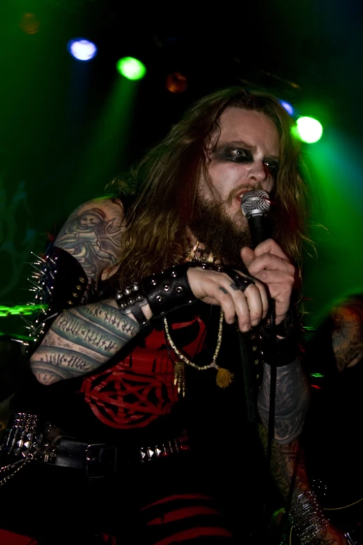 a male in a black shirt and a beard holds a microphone