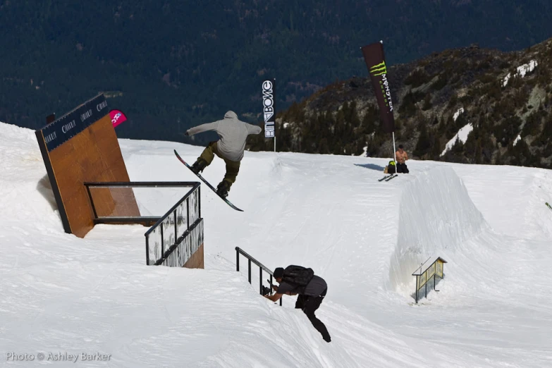 skiers are doing tricks on a snowy slope