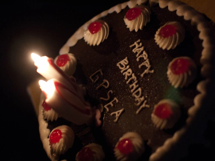 a birthday cake with white candles on a table