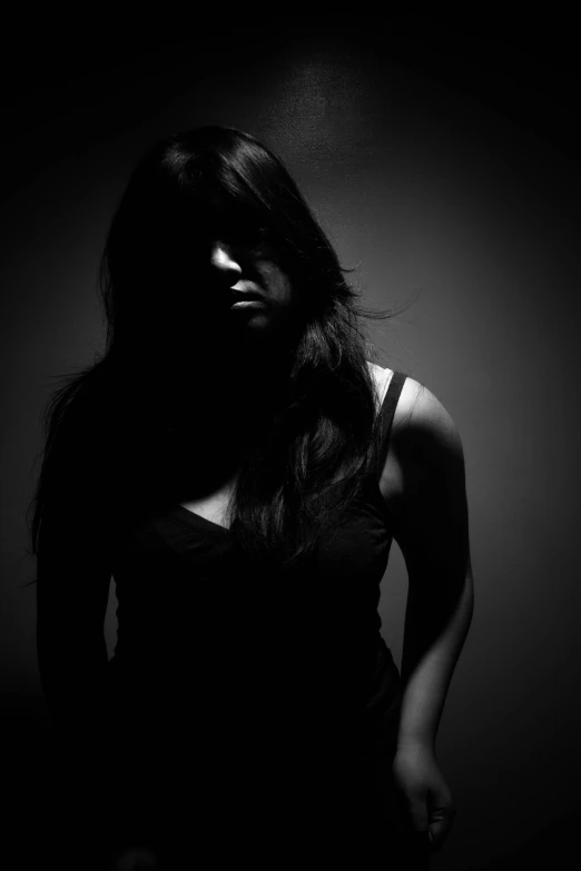 a beautiful woman standing in front of a dark background