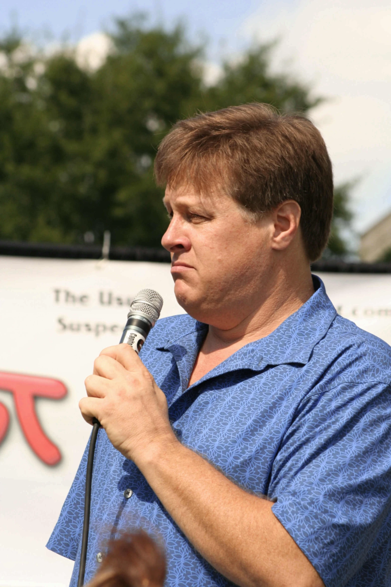 a man in a blue shirt is holding a microphone