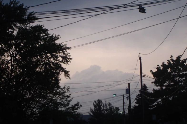 looking up at power lines and a sky with a cloud