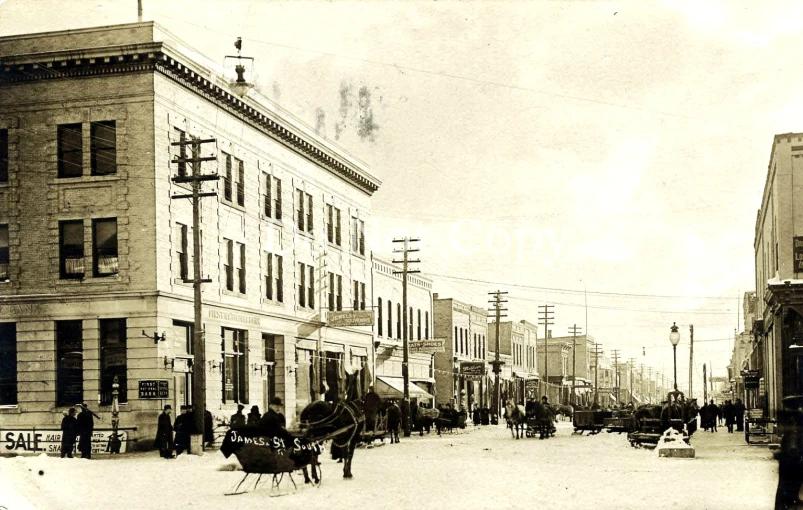 a horse drawn buggy driving down a snowy street