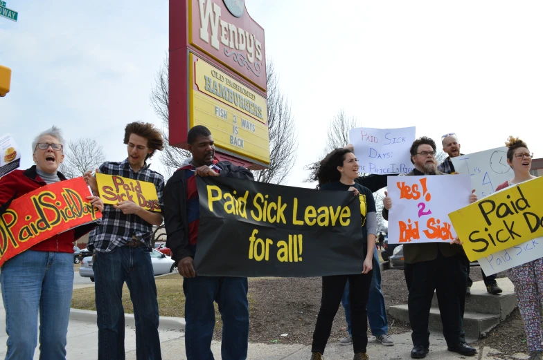 people holding signs in protest of food stamps
