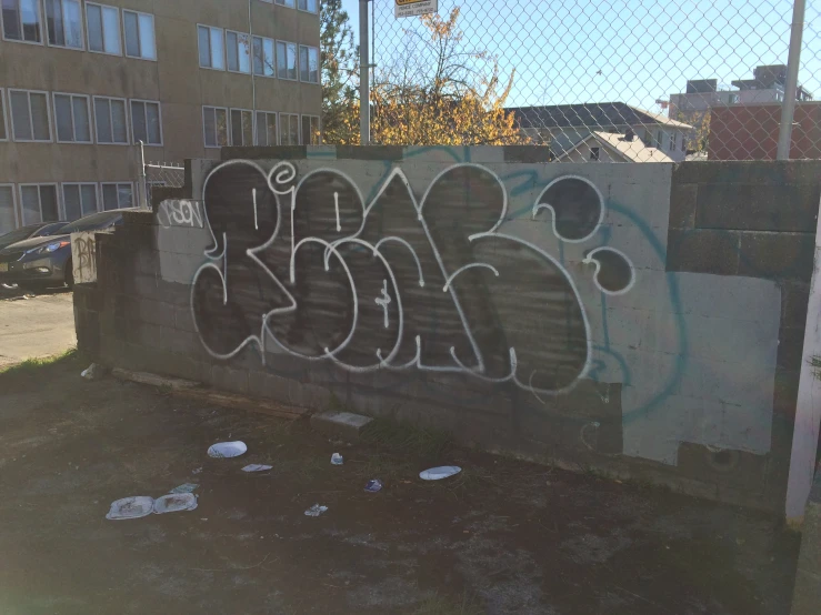 a close up of graffiti on a fence in front of an apartment building