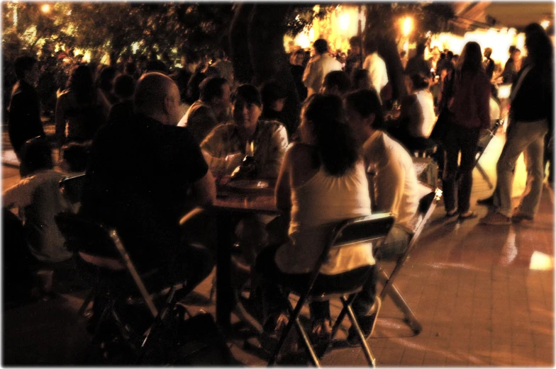 group of people sitting at tables in a large indoor eating area