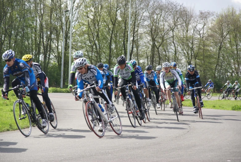 a group of bicyclists riding down the street together