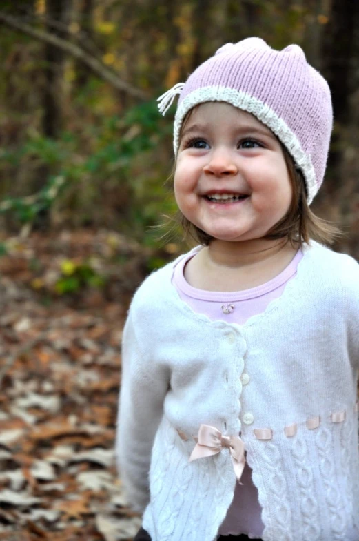 a  is smiling wearing a pink hat and sweater