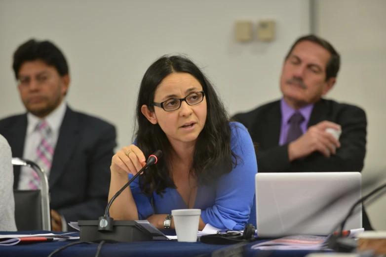 a woman at a meeting while holding a microphone