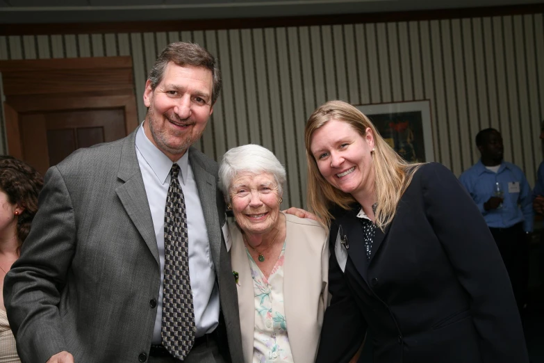 two women and a man pose together at an event