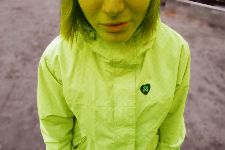 a girl with green hair wearing a lime green coat