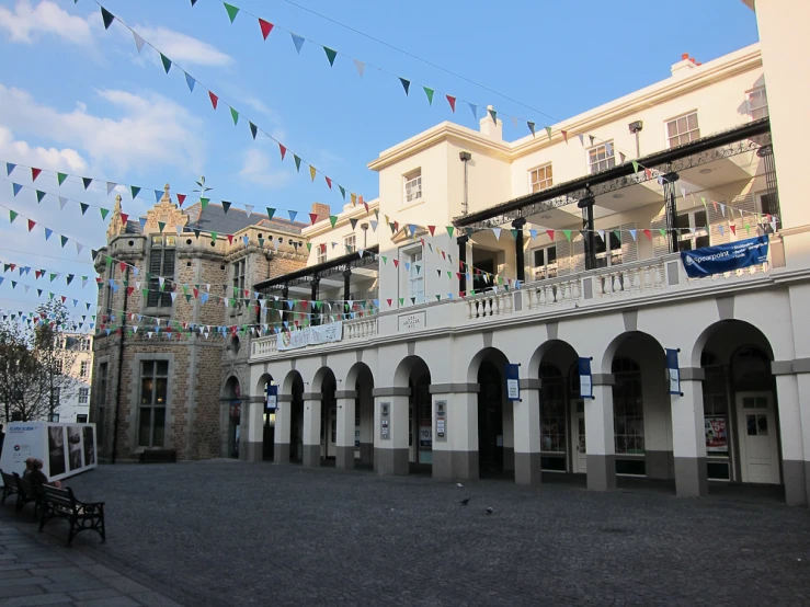 there is a building that has many flags hanging from the building