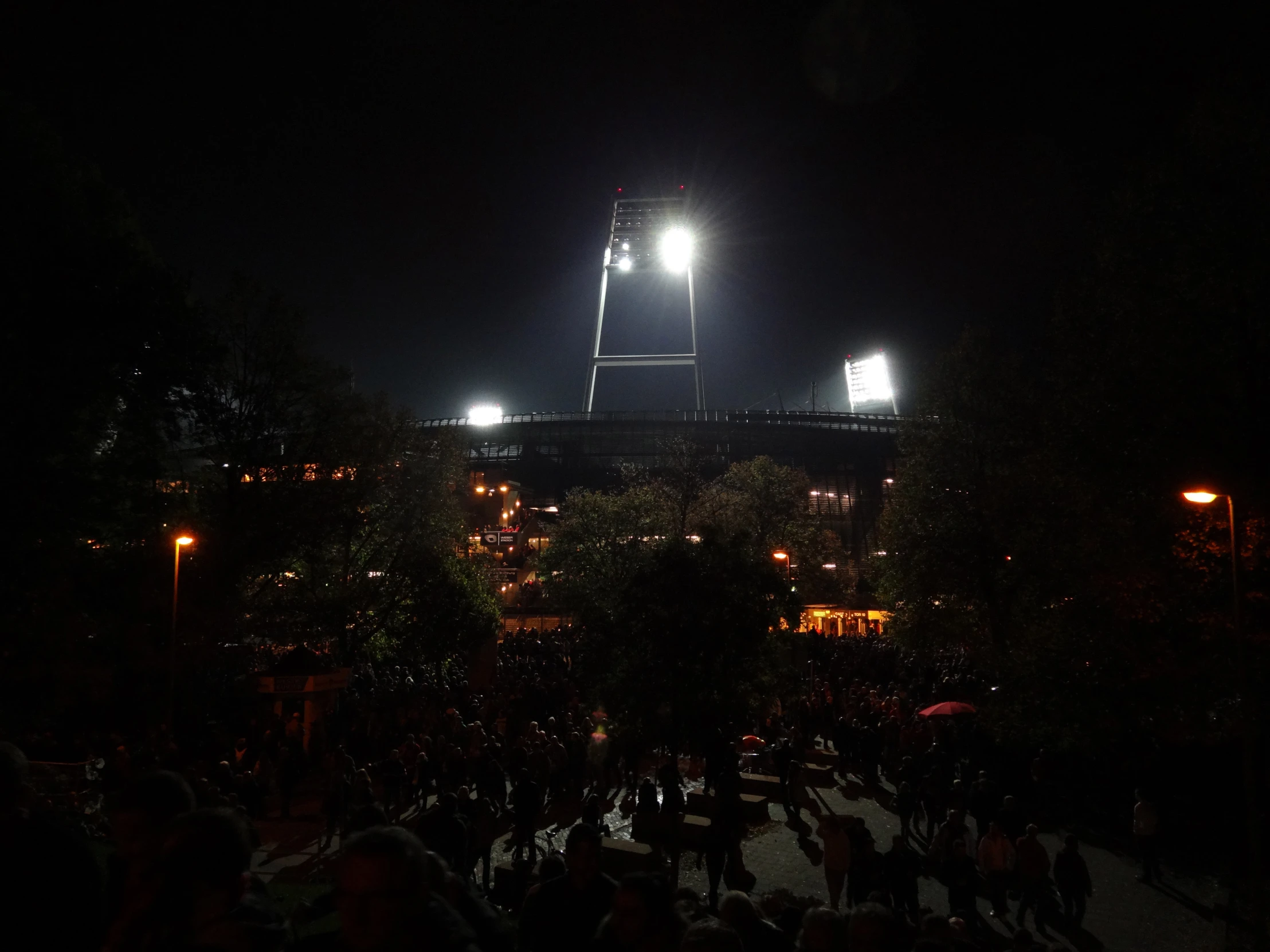 people gathered around in the nighttime on a street