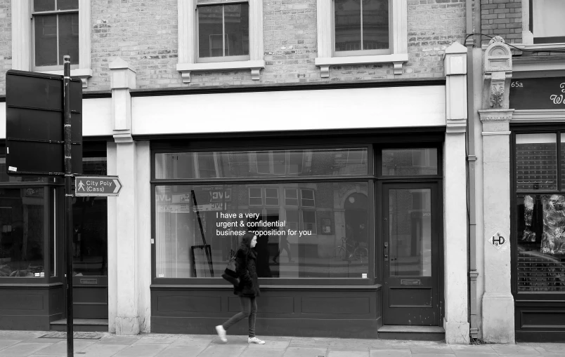 a lady walking past a store front window