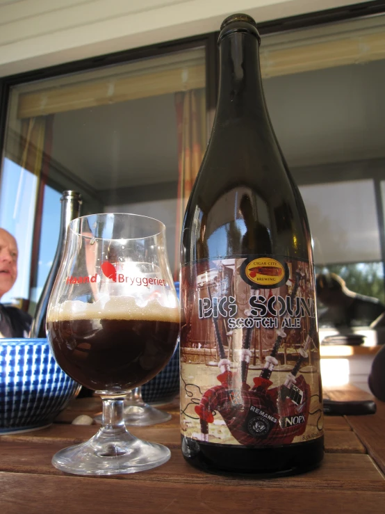 a bottle of wine sitting next to a glass full of beer