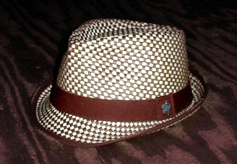 a hat with a brown ribbon and some dots