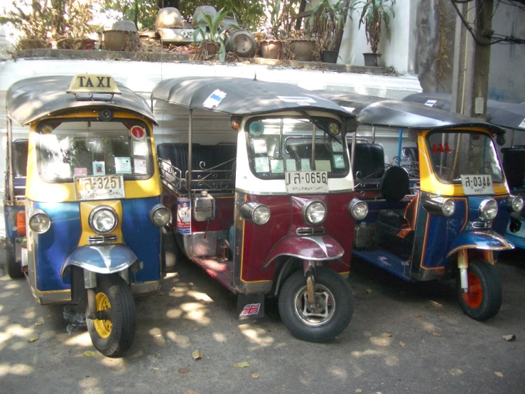 three vans in different colors, parked next to each other