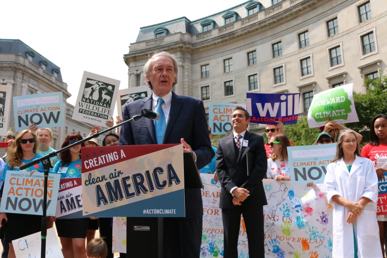 a man holding up a sign standing next to another man