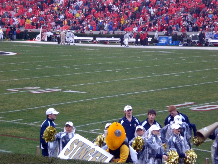 a team is carrying an i - sign in front of a football field