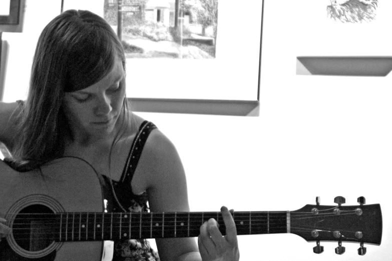 a woman holding an acoustic guitar in a room