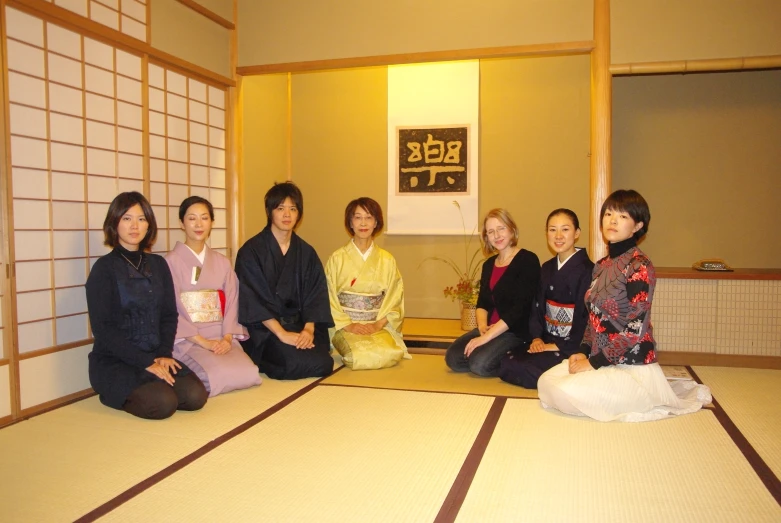 people in kimonos posing for a po while on the floor