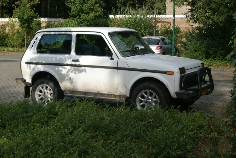 white jeep sits parked next to another car