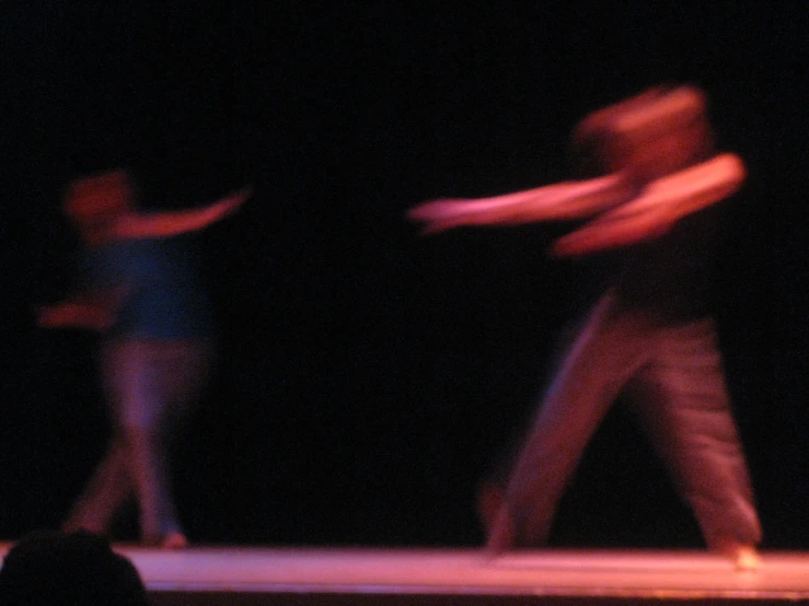 two people in motion on a stage