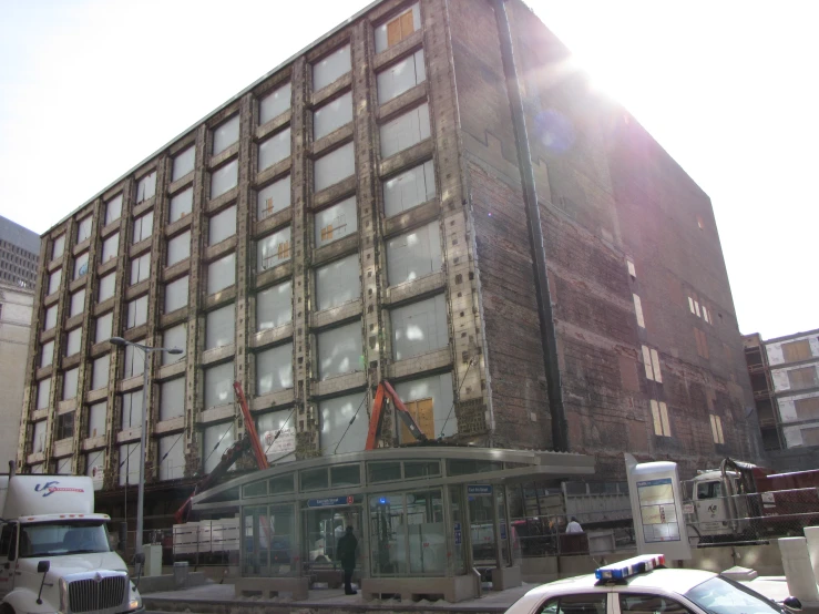 cars and a police truck driving in front of a building