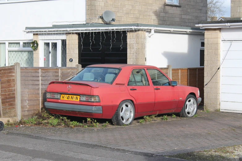 red car parked in front of a brick building