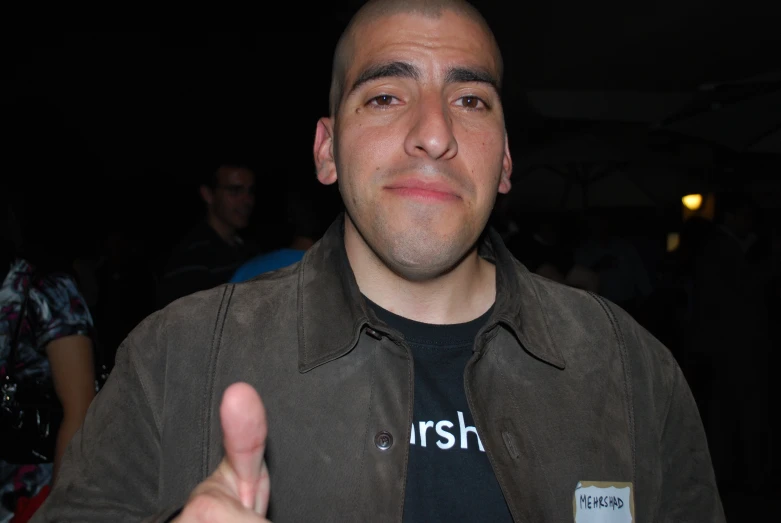 a man posing for the camera with one hand and his thumb up