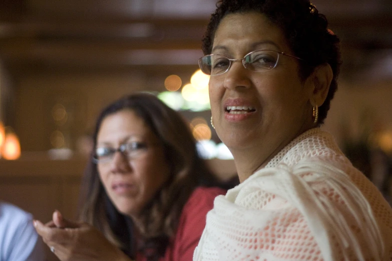 a close up of two people smiling with a woman pointing