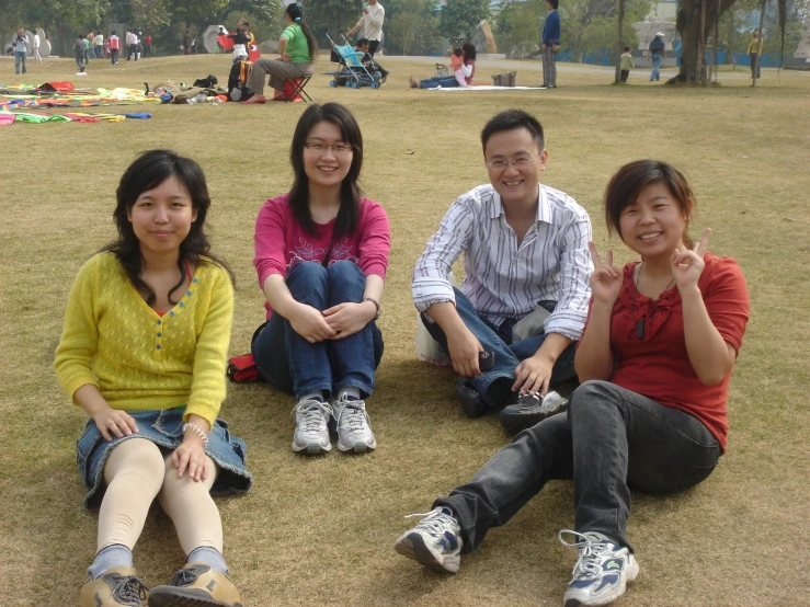 a group of people sitting next to each other on a field