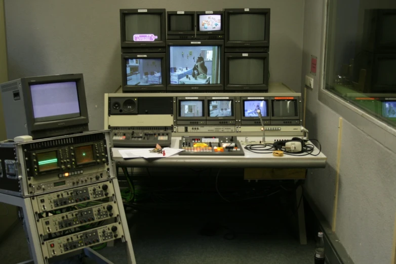 a room full of computer screens with several televisions in front