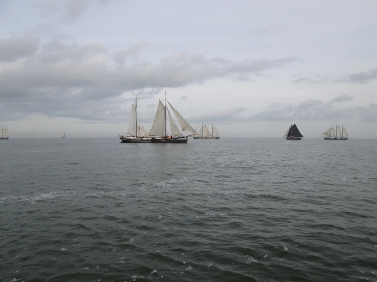 a group of boats sailing across the ocean