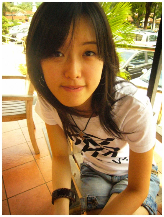 a girl sitting on a chair holding an apple in her hand