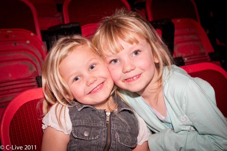 two children are hugging each other at the movies