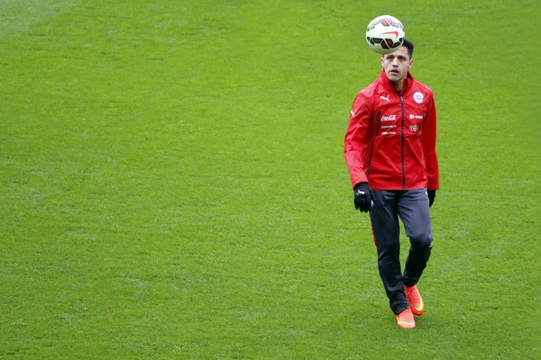 soccer player in red and black with his head up on the field