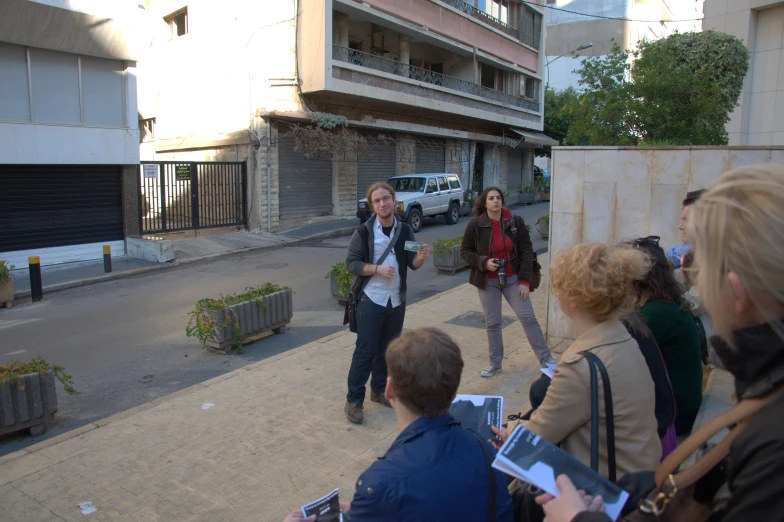 some people are standing outside with cameras on the sidewalk