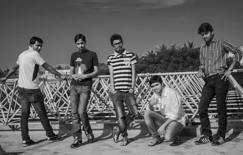 several young men are sitting on the bridge together