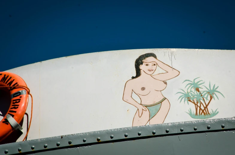 a painted cartoon girl in bikini next to the sign