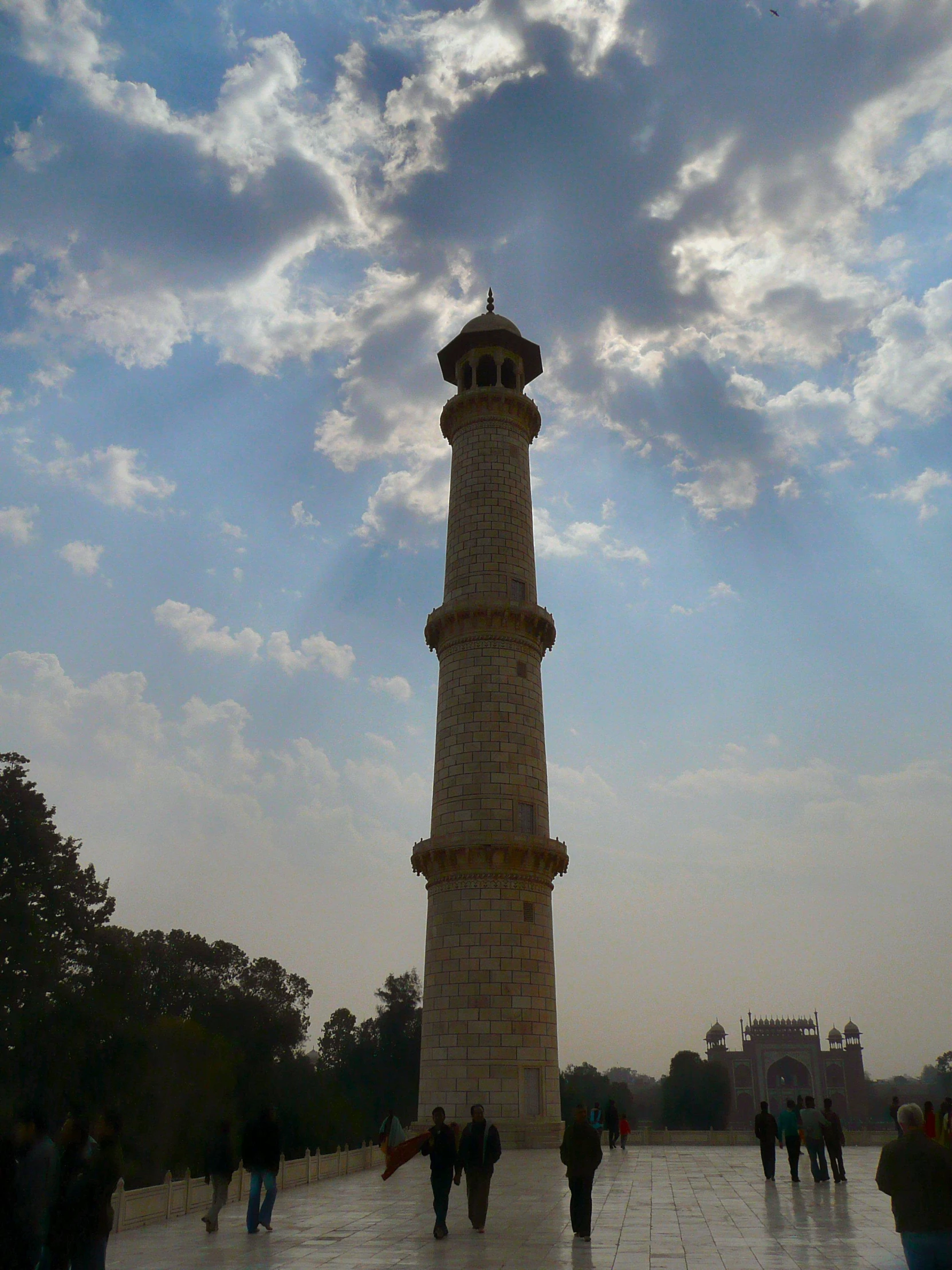 a tall tower sits at the top of a cobblestone path