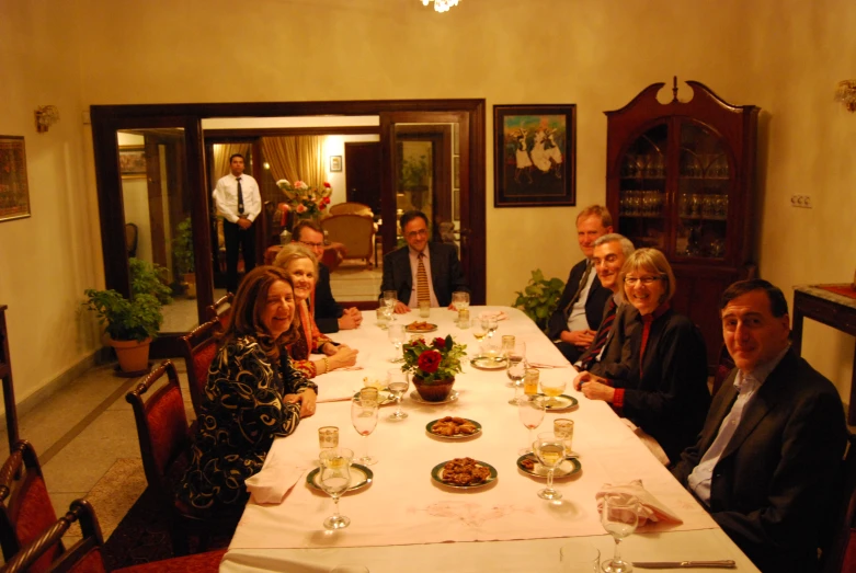 five people are gathered at a large table with drinks in front of them