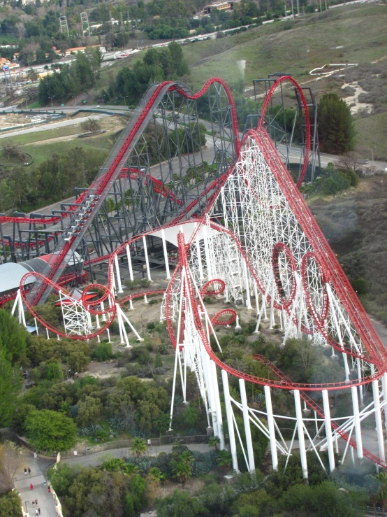 a roller coaster rides over a hill in a large town